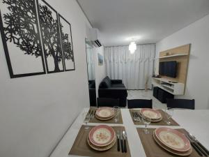 uma sala de jantar com uma mesa e uma sala de estar em MAKARANDUBA BEACH 304 - Piscinas Naturais e Coração de Porto em Porto de Galinhas