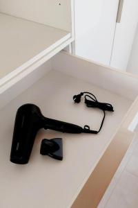 a black hair dryer sitting on top of a shelf at Old Town Studios in Parga
