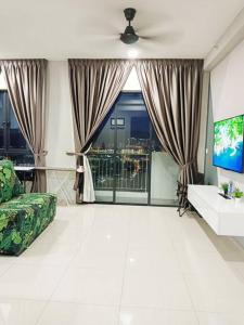 a living room with a couch and a tv at Bayan Lepas Cozy Family Stay Sea & Airport View in Kampong Batu Maung