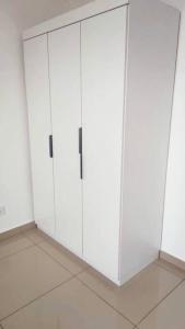 a white cabinet with two doors in a room at Bayan Lepas Cozy Family Stay Sea & Airport View in Kampong Batu Maung