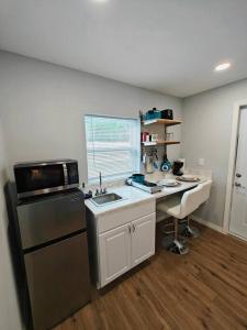 a kitchen with a sink and a desk with a microwave at Gorgeous suite central location in St. Petersburg
