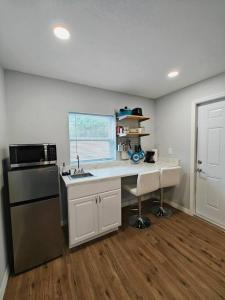 a kitchen with a desk and a sink and a microwave at Gorgeous suite central location in St Petersburg