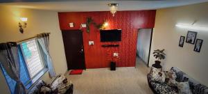 a living room with a red wall with a tv at Venus Villa in Panchgani