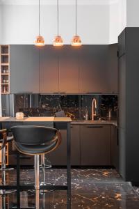 une cuisine avec des armoires noires et un comptoir noir dans l'établissement NEW High-End 2BR Apartment with Parking, à Sofia