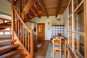 cocina y comedor con escaleras de madera y mesa en Landlust-Ferienhaus Am Rosenhof, en Hartberg