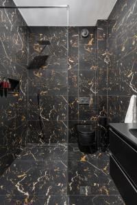 a black and gold bathroom with a toilet and a sink at NEW High-End 2BR Apartment with Parking in Sofia