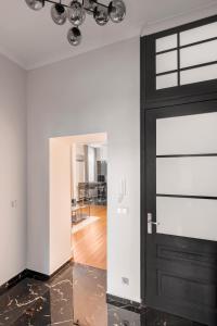 a hallway with a black door and a living room at NEW High-End 2BR Apartment with Parking in Sofia