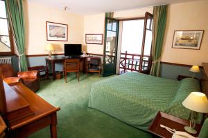 um quarto de hotel com uma cama e uma secretária com um computador em Manoir Du Cunningham em Saint Malo