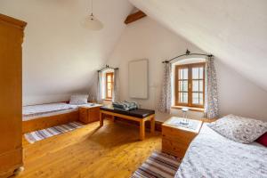 Zimmer im Dachgeschoss mit 2 Betten und einem Spiegel in der Unterkunft Landlust-Ferienhaus Am Rosenhof in Hartberg
