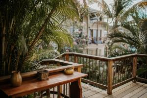 a wooden deck with a table and palm trees at Cruz Bay Tropical Condo in Bethany
