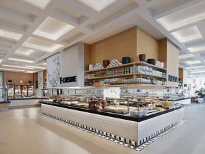 a restaurant with a counter with a lot of food at Voyage Torba Hotel in Torba