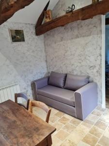 a living room with a couch and a table at PETIT GÎTE 18 ème tout confort in Saint-Germain-des-Fossés