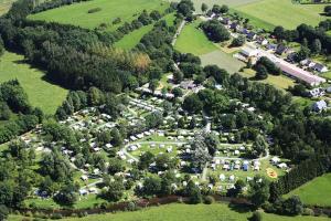 een uitzicht over een park met bomen en huizen bij Camping De Chênefleur in Tintigny