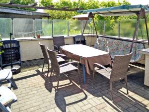 einen Tisch mit Stühlen und einem Sonnenschirm auf einer Terrasse in der Unterkunft Apartments Greifswalder Chaussee in Stralsund