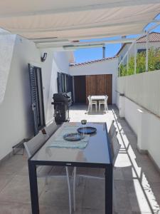 a patio with a table and chairs and a grill at Villa Ocean Waves in Aroeira