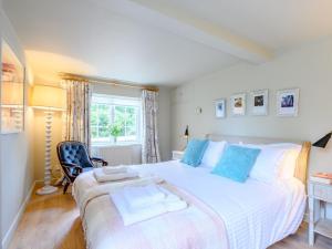 a bedroom with a large white bed with blue pillows at 1 Bed in Beaulieu 78926 in Beaulieu
