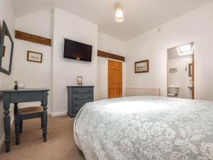 a bedroom with a bed and a desk and a tv at 2 Bed in Filey 79280 in Wold Newton