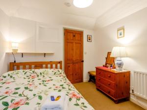 a bedroom with a bed and a wooden dresser at 3 bed property in Bath 79174 in Chilcompton