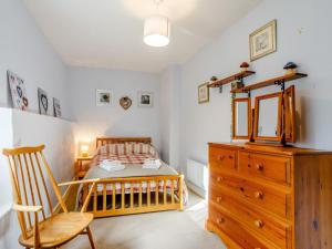 a bedroom with a bed and a wooden dresser at 3 bed property in Bath 79174 in Chilcompton