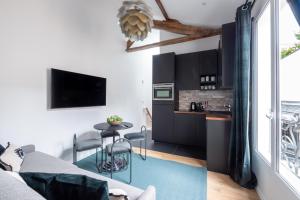 uma cozinha e sala de estar com um sofá e uma mesa em Au centre de paris - 4pax em Paris