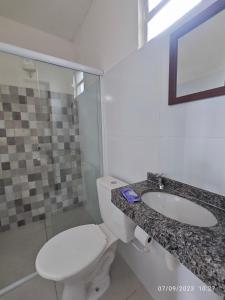 a bathroom with a toilet and a sink at Pousada Villa Graciela in Ilhéus