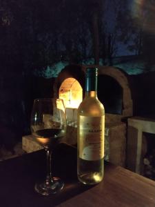 una botella de vino y una copa en una mesa en Casa MAGNOLIA en Chacras de Coria