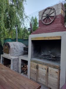 cocina al aire libre con horno de pizza y fogones en Casa MAGNOLIA en Chacras de Coria