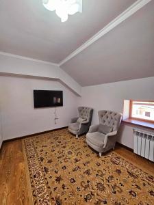 Privokzalʼnoye的住宿－Эсалу Гостиный Дом，客厅配有2把椅子和平面电视