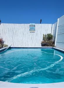 a swimming pool with blue water in front of a fence at APPLES APARTMENT 6B in Cape Town