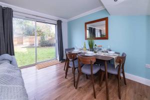 uma sala de jantar com uma mesa e cadeiras e uma janela em Ratby House - Spacious 3 Bed with Garden & Parking em Earley