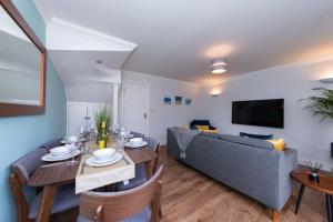 un soggiorno con divano blu e tavolo di Ratby House - Spacious 3 Bed with Garden & Parking a Earley
