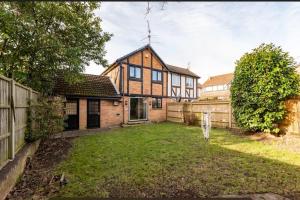 uma casa grande com uma cerca e um quintal em Ratby House - Spacious 3 Bed with Garden & Parking em Earley
