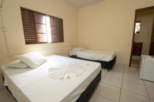 a room with two beds and a window at Avenida Hotel in Presidente Prudente