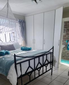 a bedroom with a bed with blue pillows on it at APPLES APARTMENT 6B in Cape Town
