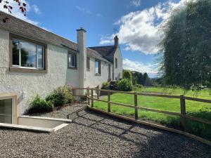 a house with a wooden fence next to a field at 2 Bed in Blair Drummond 81513 in Doune