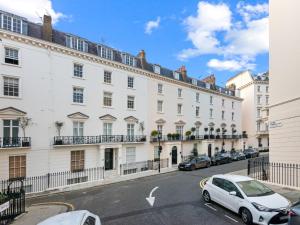 a white building with cars parked in front of it at Londwell, Sloane Square Gem, Private Terrace Suite in London