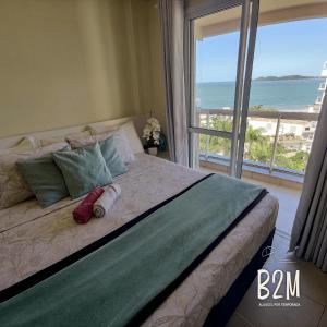 a bedroom with a bed with a view of the ocean at Beto Carrero, vista Espetacular do mar, Home Club in Penha