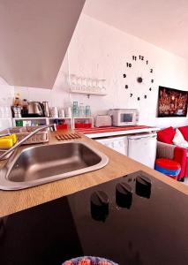 een keuken met een wastafel en een klok aan de muur bij La Casita Sun Beach in Caleta De Fuste