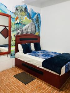 a bedroom with a bed with a painting on the wall at Siumi Rest in Nallathanniya