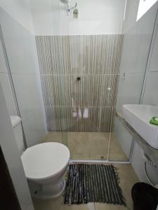 a bathroom with a toilet and a shower and a sink at Pousada Villa Graciela in Ilhéus