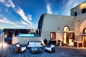 a villa with a swimming pool and a patio at Santorini Heritage Villas in Megalochori