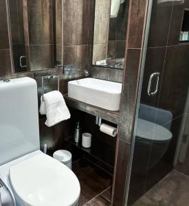 a bathroom with a sink and a toilet and a mirror at Londwell, Sloane Square Gem, Private Terrace Suite in London