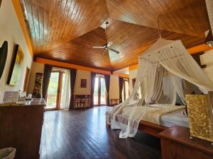 um quarto com uma cama e um tecto em madeira em The Gana Ubud by Guru experience em Ubud