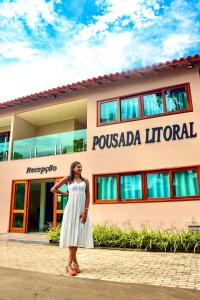 a woman in a white dress standing in front of a building at Pousada Litoral Paraty in Paraty