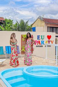 two women are standing next to a swimming pool at Pousada Litoral Paraty in Paraty