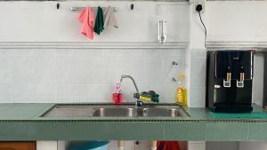 a kitchen with a sink and a green counter top at 吉隆坡疯鱼民宿Crazy Fish Homestay KL in Petaling Jaya