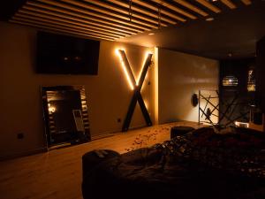 a room with a large x sign on the wall at Douceur du Charme - Love-room à Charmes entre Epinal et nancy in Charmes +12 photos