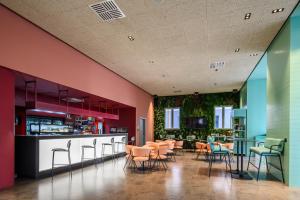 un restaurante con paredes coloridas, mesas y sillas en CX Venice Mestre en Mestre