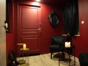 a red room with a red door and a chair and candles at Douceur du Charme - Love-room à Charmes entre Epinal et nancy in Charmes