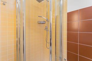 un bagno con doccia e piastrelle gialle di Helios Rooms by Wonderful Italy a Conversano